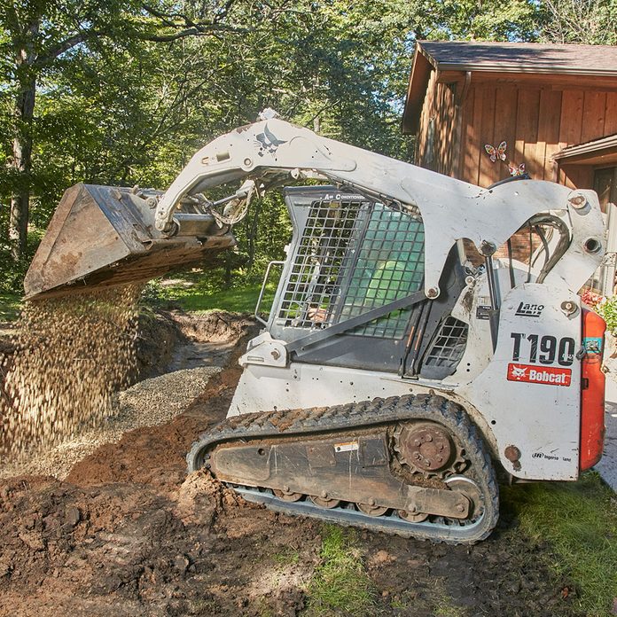 Laying a rock base with a Bobcat | Construction Pro Tips