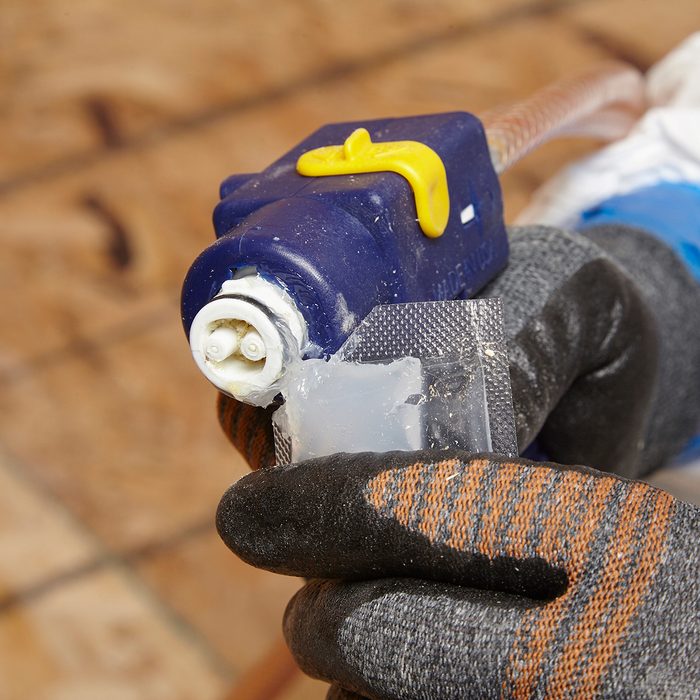 Lubing the tip of a spray foam gun | Construction Pro Tips