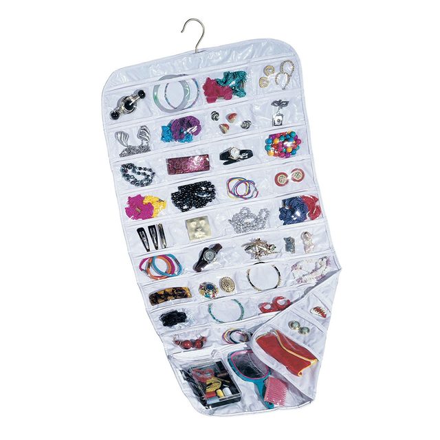 A hanging jewelry organizer displays various accessories, including bracelets, earrings, and necklaces, neatly arranged in transparent pockets against a light background.