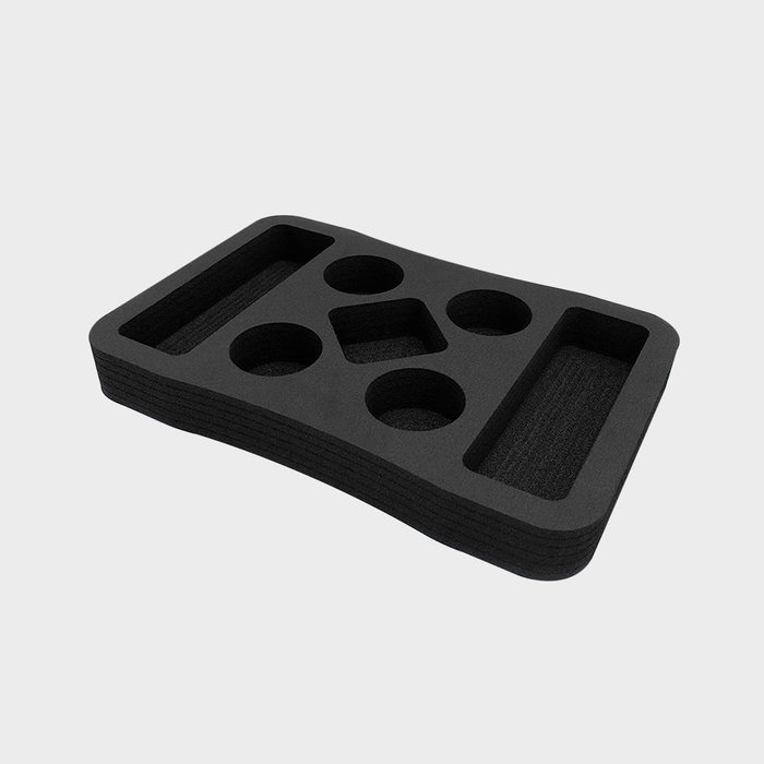 A black tray with assorted shaped cutouts rests flat. It offers organized compartments for storing various items, enhancing workspace efficiency.