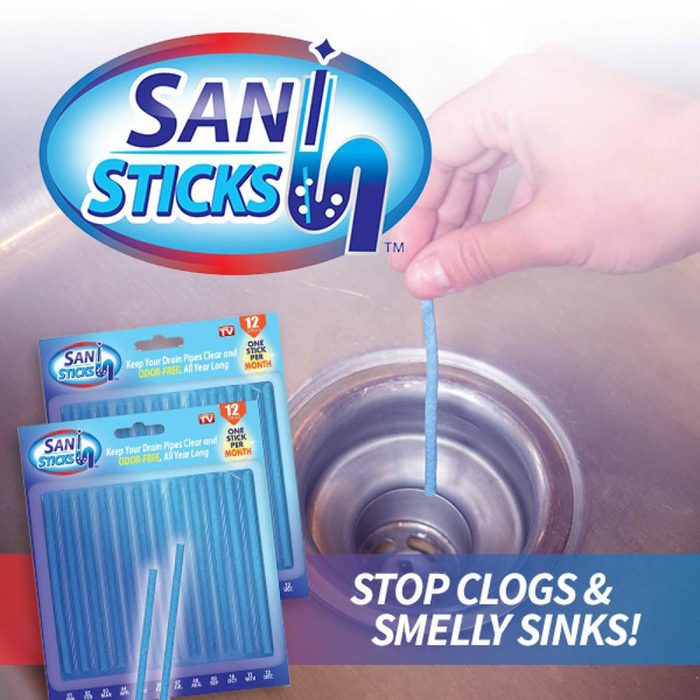 A hand inserts a blue cleaning stick into a sink drain, with two packages of SAN STICKS visible nearby. Text reads: 