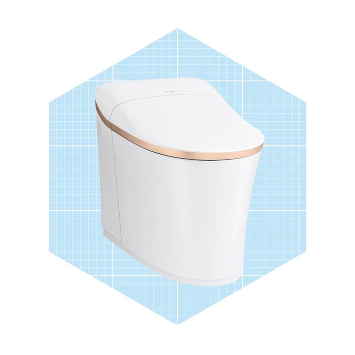 A modern toilet with a sleek design features a white surface and a gold accent. It is displayed against a light blue grid background.