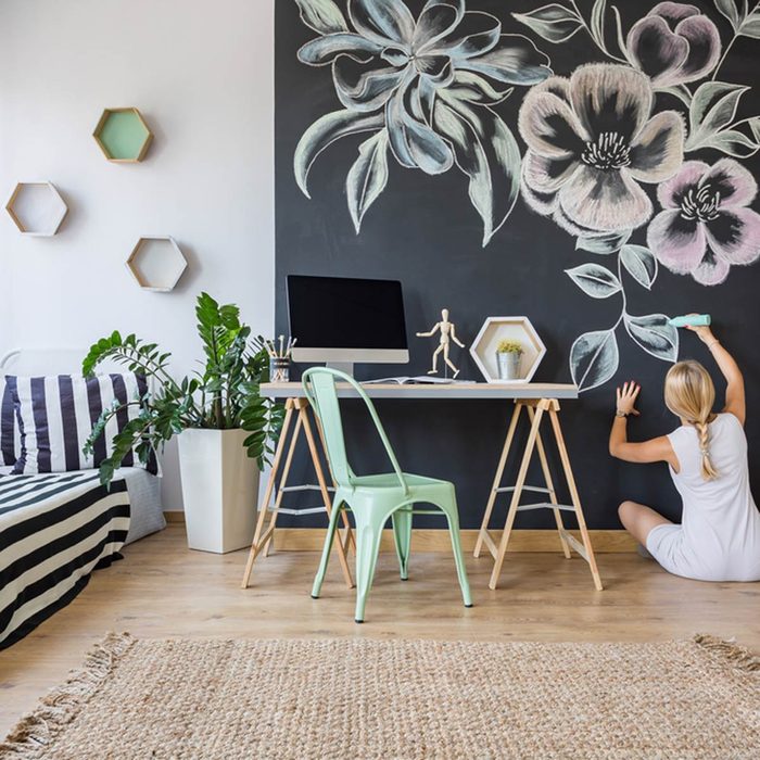 Lady Drawing on Wall with Colourful Chalks
