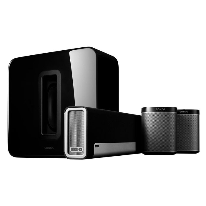 A black speaker system features a rectangular subwoofer and two cylindrical speakers, positioned to create a compact audio setup focused on delivering sound.