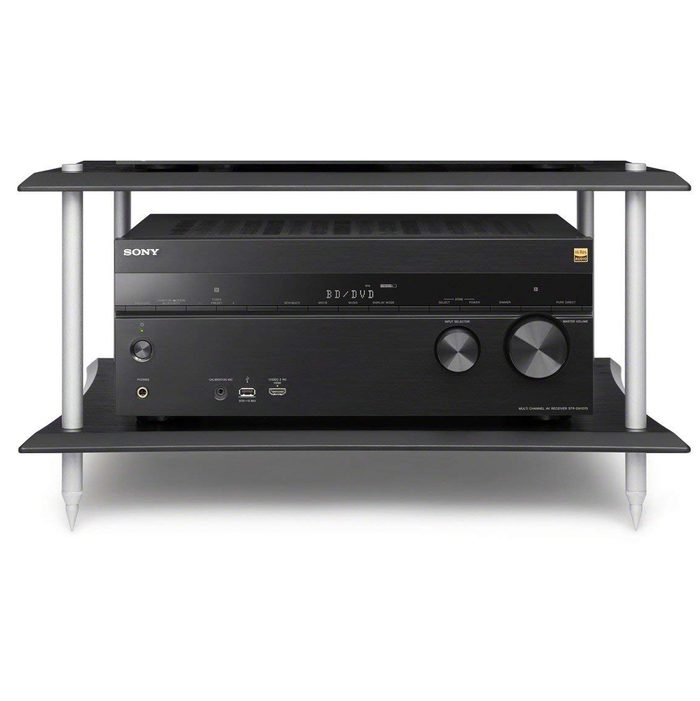 A black audio receiver with control knobs is positioned on a two-tier shelf, surrounded by a simple, modern framework and supporting legs.