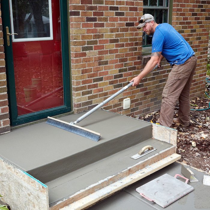 Brooming the top of the sidewalk for a nice finish | Construction Pro Tips