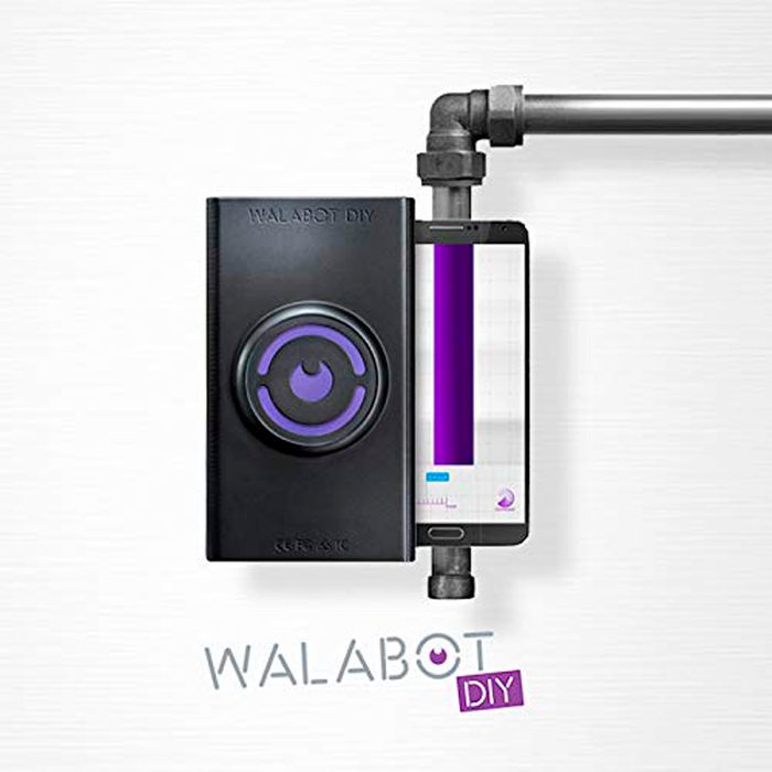 A black device with a circular design connects to a smartphone, displaying a digital interface, against a light background with a purple accent.