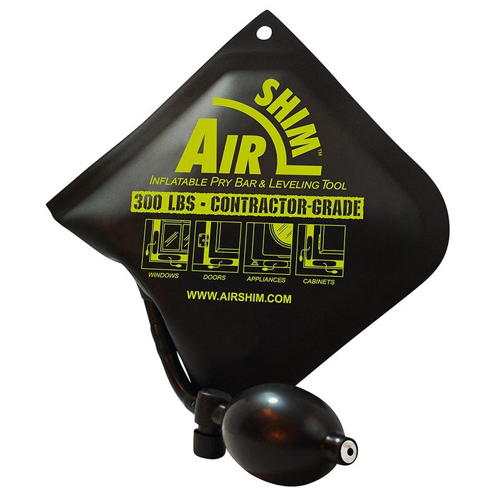 An inflatable pry bar and leveling tool rests on a surface. It is designed for positioning objects like windows and doors, featuring a pump mechanism.