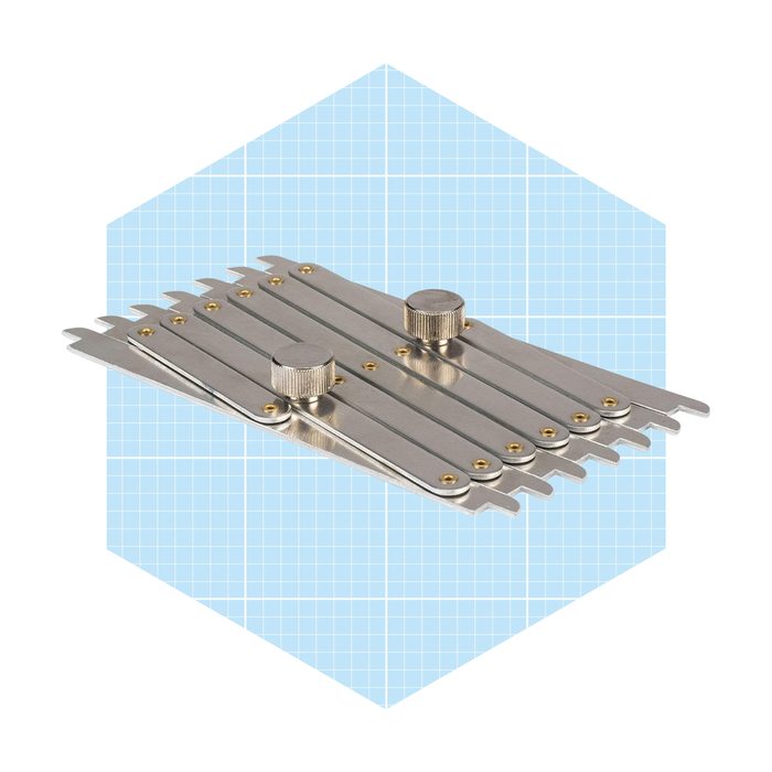 A set of metal gauges is displayed. They are being arranged for measurement tasks on a light blue, grid-patterned background.