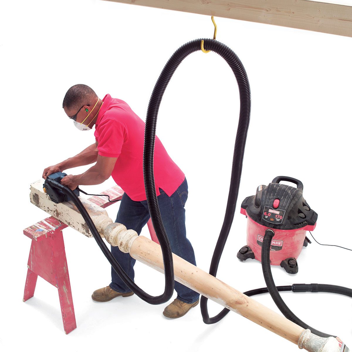 Man using a dust control system handing from a ceiling hook | Construction Pro Tips
