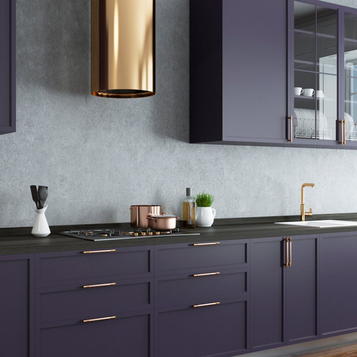 A modern kitchen features dark cabinetry and a golden pendant light. A stovetop holds pots, surrounded by utensils and decor against a concrete wall.