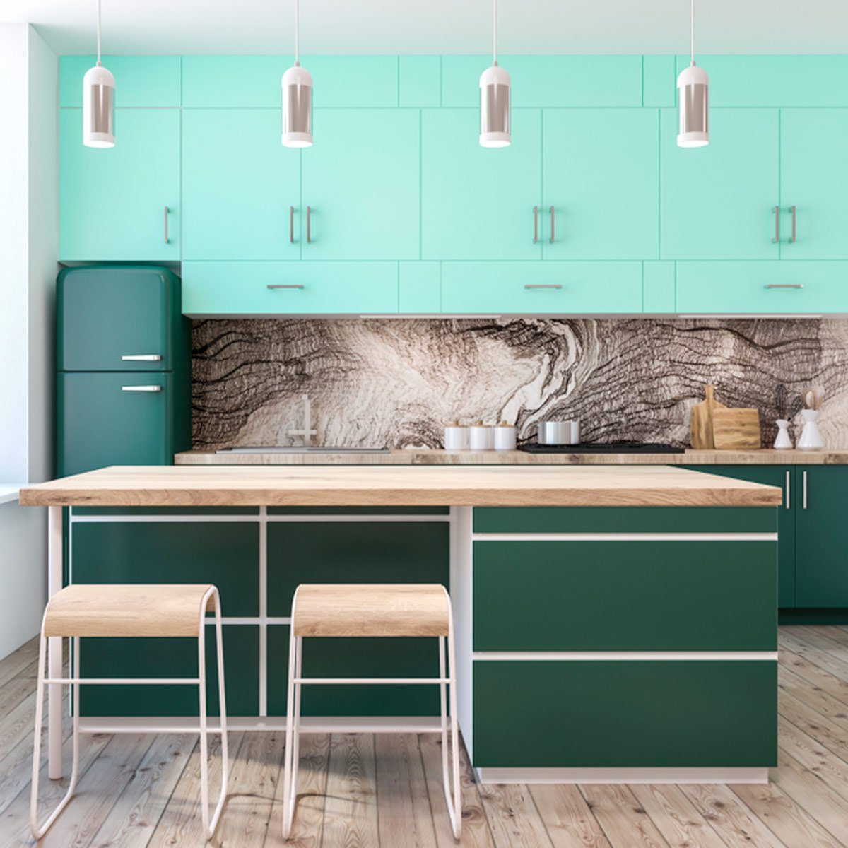 A modern kitchen features a wooden island with green cabinetry, two stools, and light fixtures, set against a textured stone backsplash.