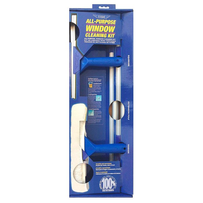 A window cleaning kit is displayed in a package, featuring a squeegee, extension pole, and cleaning cloth, designed for home use.
