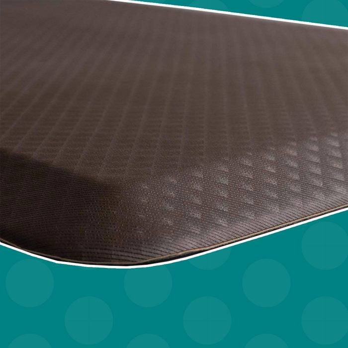 A textured brown mat rests on a turquoise background, showcasing its subtle patterns and rounded edges.