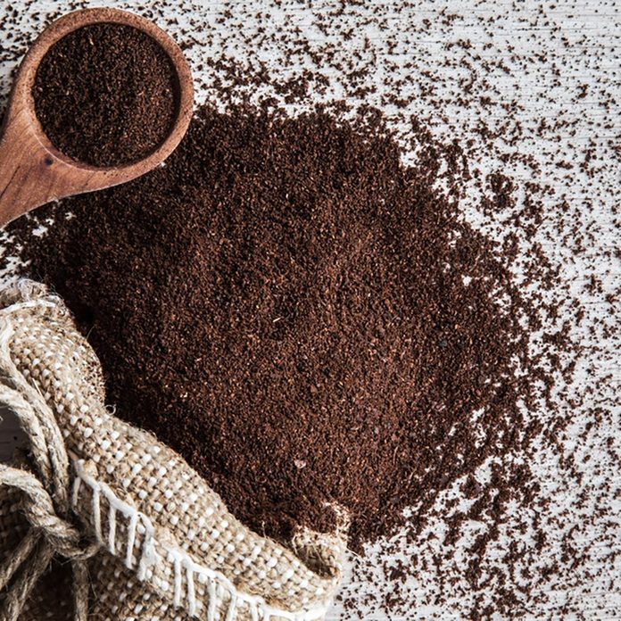 Ground coffee with burlap bag on the wooden table in the kitchen