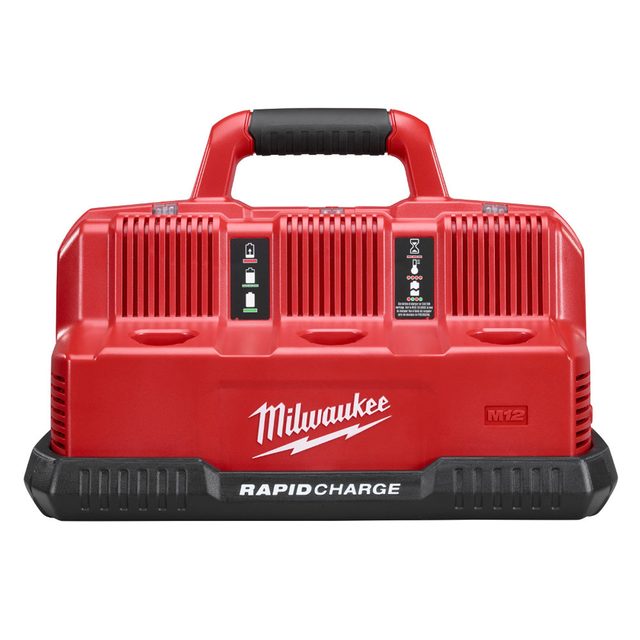 A red battery charger with a handle is positioned upright, displaying charging indicators and branding, designed for Milwaukee M12 batteries in a tool-oriented context.