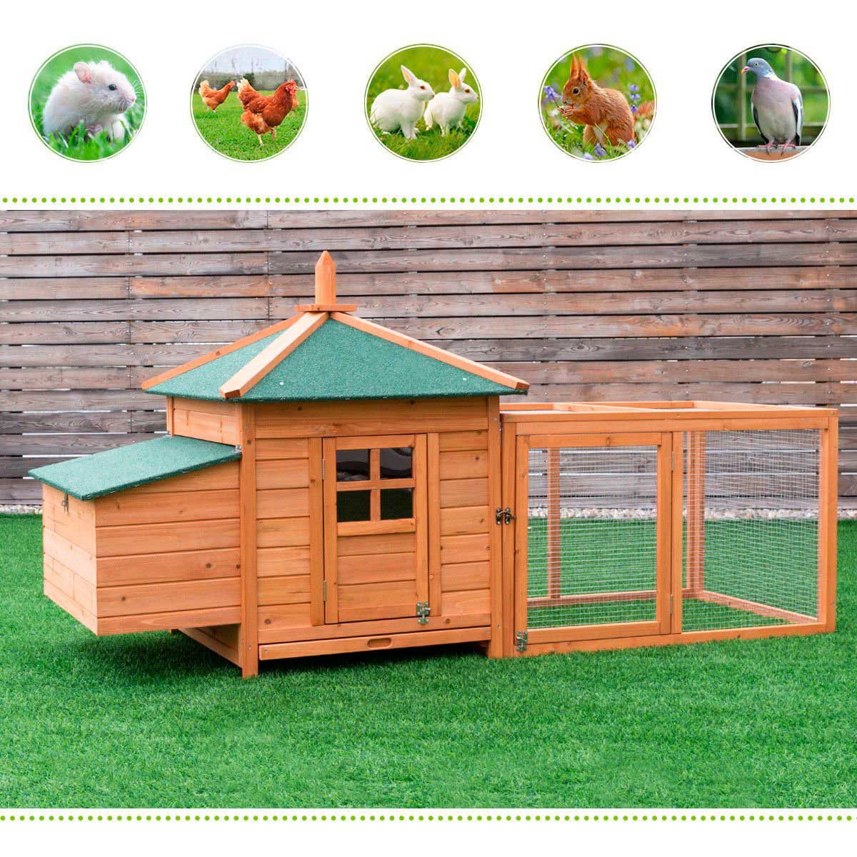 A wooden animal house with a green roof sits on grass, connected to a wire enclosure, providing shelter and space for small animals.