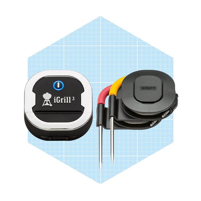 A wireless cooking thermometer with two attached probes rests against a light blue geometric background, showcasing its sleek design and functionality for grilling.