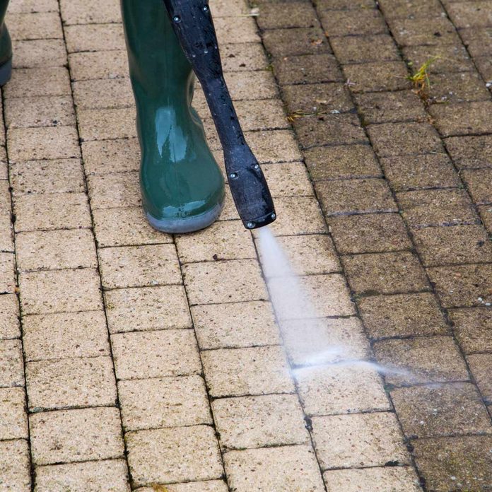 Person-pressure-washes-brick