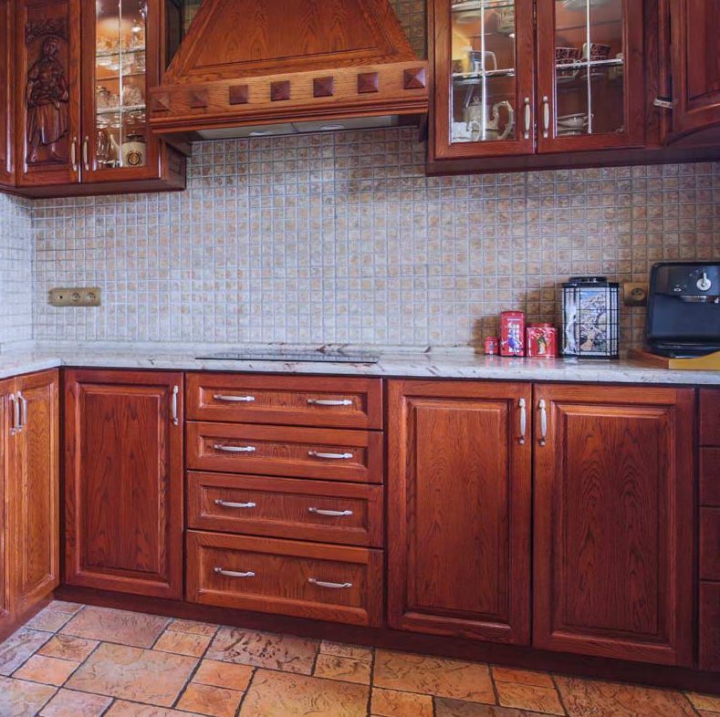 kitchen with cherry wood cabinets and a natural stone mosaic backsplash