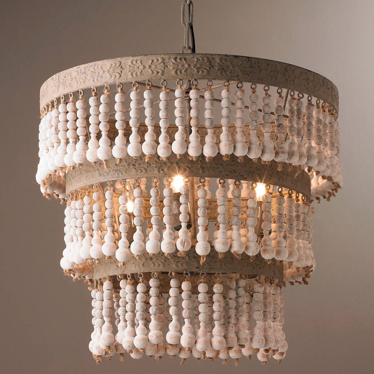 A decorative chandelier hangs from the ceiling, featuring multiple tiers of white beads and soft light emanating from within, enhancing a cozy atmosphere.