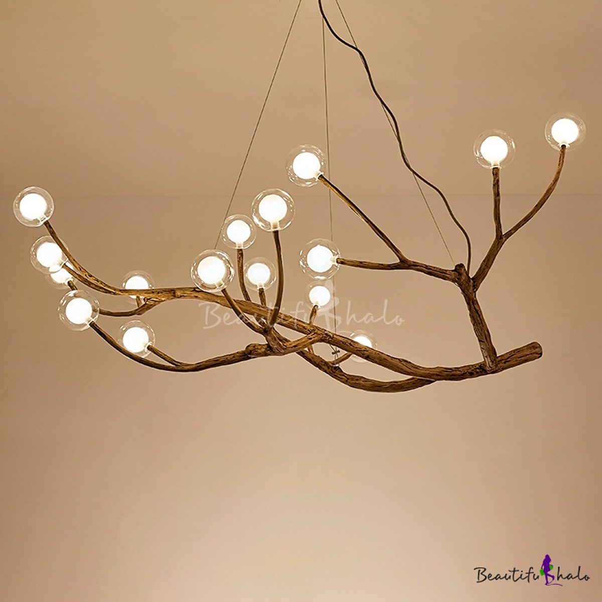 A chandelier resembling branches features multiple light bulbs, suspended from the ceiling against a plain background, providing ambient illumination.