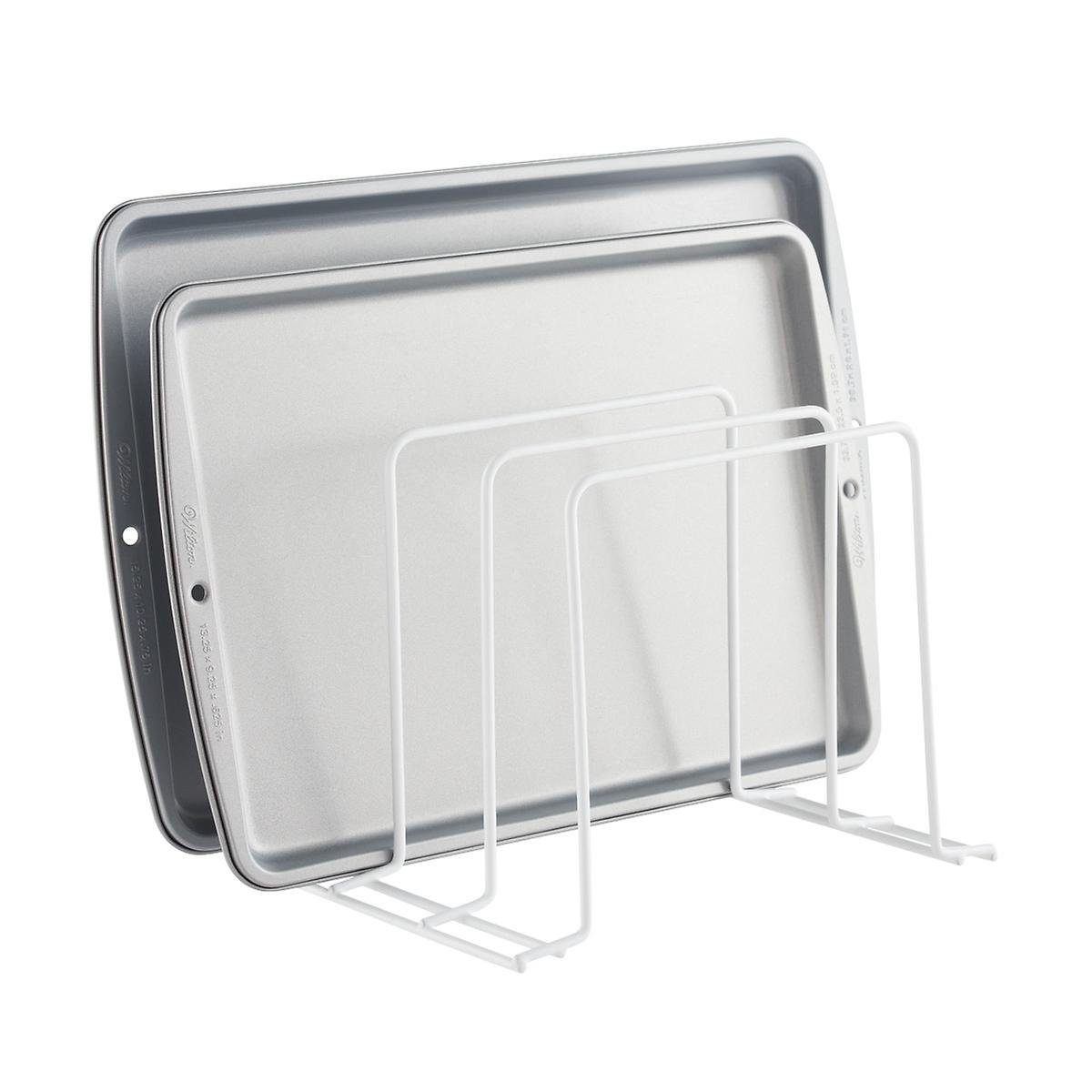Two baking trays rest vertically in a white wire rack, designed to organize kitchen items efficiently. The background is simple and uncluttered.