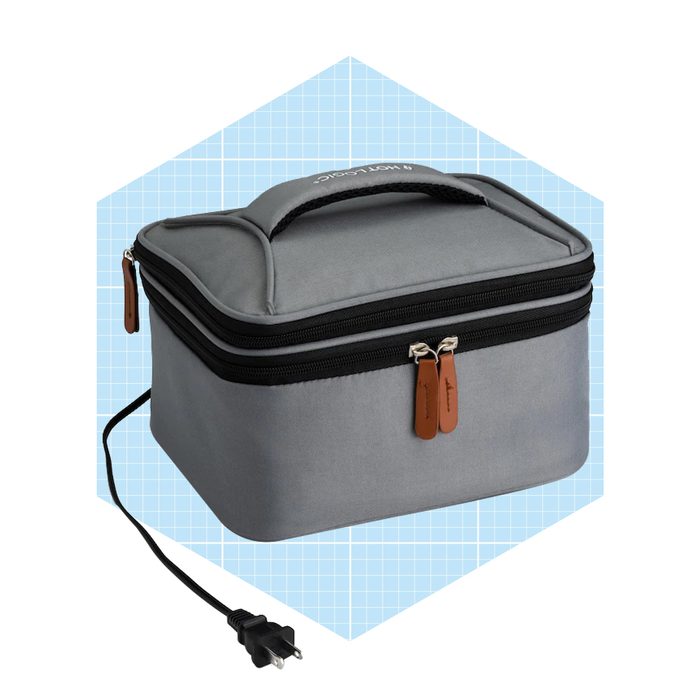A gray insulated bag with a zipper and a handle sits on a light blue grid background, featuring a power cord connected to it.
