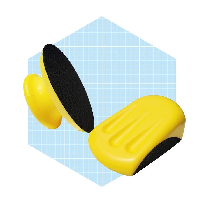 A yellow ergonomic wrist rest supports hands during typing, positioned on a light blue grid background to enhance visibility and clarity.