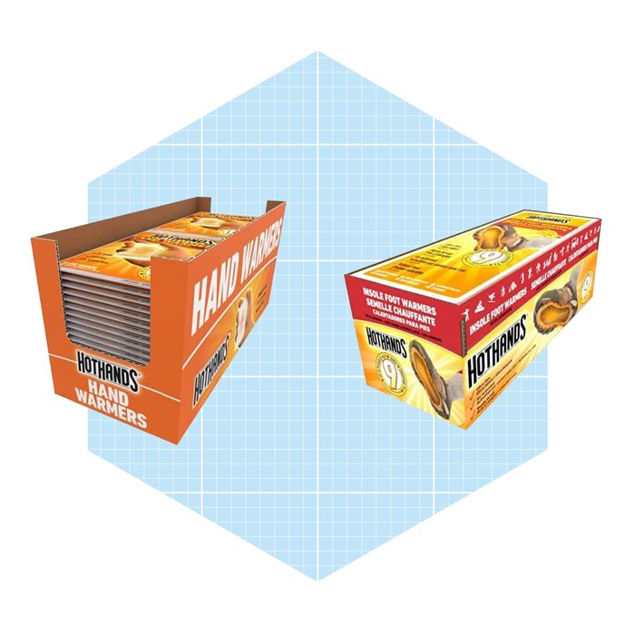 Two boxes of Hothands hand and foot warmers are displayed on a light blue grid background, showcasing their packaging and brand name prominently.