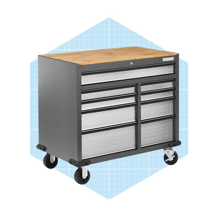 A mobile tool chest with a wooden top and multiple drawers is positioned on wheels against a light blue grid background.