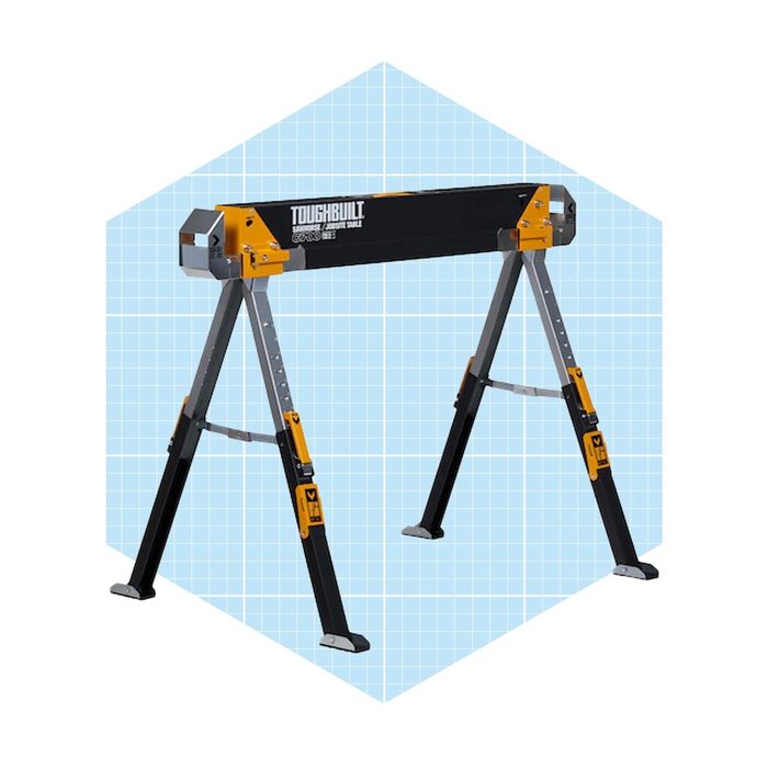 A sturdy folding sawhorse supports a flat surface, providing a workspace. It's set against a light blue grid background, suggesting a workshop or project area.