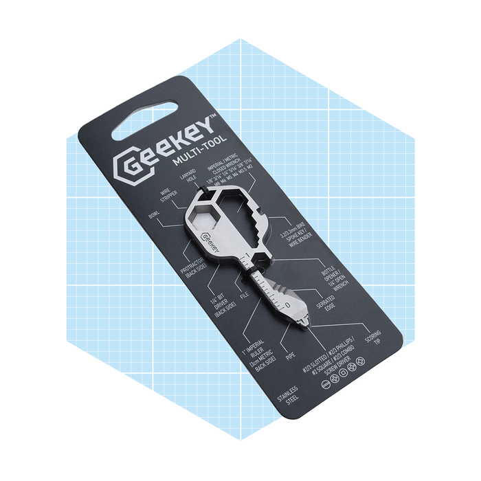 A silver multi-tool key is displayed on a card, highlighting its various functions and features against a light blue grid background.