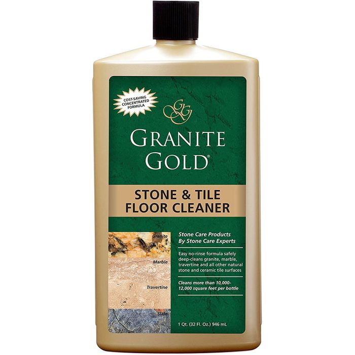 A bottle of Granite Gold floor cleaner stands upright. It contains a no-rinse formula designed for cleaning stone and tile surfaces, promoting deep cleaning.