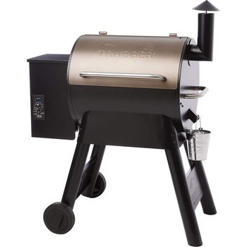 A pellet grill with a shiny bronze lid, black body, digital controls, and a smoke stack sits on sturdy legs with wheels, ready for outdoor cooking.