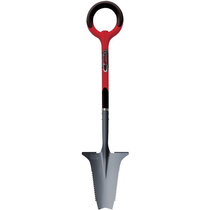 A red-handled shovel stands upright, featuring a pointed gray blade with serrated edges, designed for digging in soil or garden settings.
