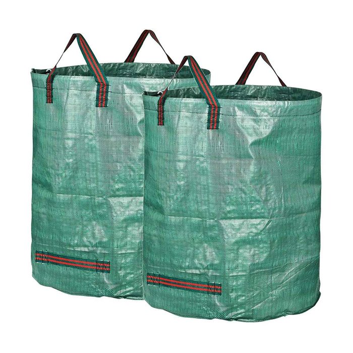 Two large, green storage bags stand upright. They are made of a woven material and feature sturdy handles, likely used for carrying or storing items.