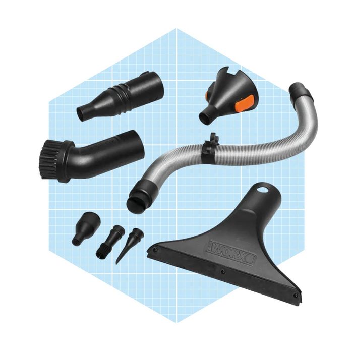 A collection of vacuum cleaner attachments lies on a blue grid background, including hoses, nozzles, and a squeegee, designed for various cleaning tasks.
