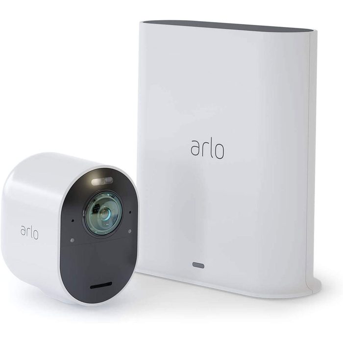 A round, white security camera sits next to a white rectangular base, both displaying the brand 