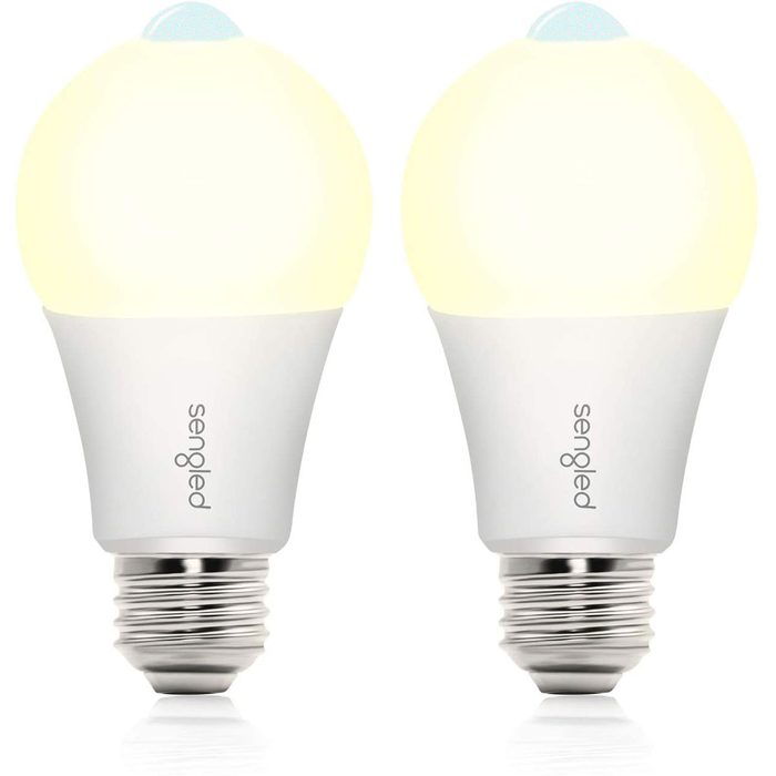 Two LED light bulbs illuminate brightly, showcasing a modern design with a smooth white body and a metallic base, suitable for standard fittings.
