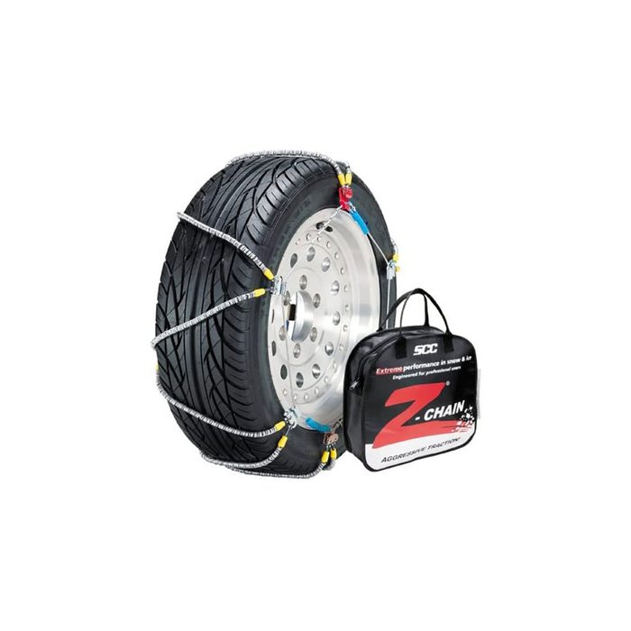 A tire with metal chains attached sits beside a black carrying bag, indicating it's designed for enhanced traction in snow and ice conditions.