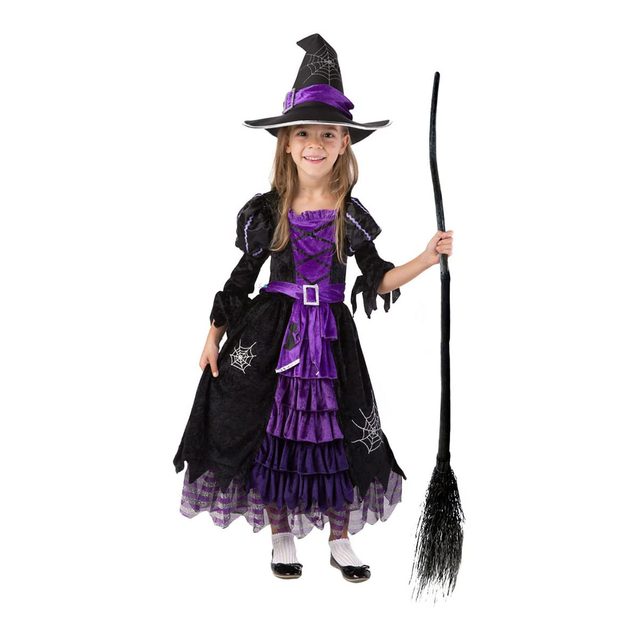 A girl in a black and purple witch costume smiles while holding a broomstick, set against a plain white background.