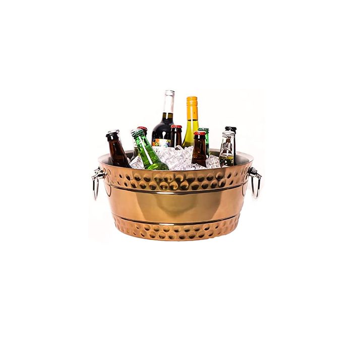 A metallic ice bucket holds various bottles and cans surrounded by ice, designed for chilling beverages in a celebratory or casual gathering setting.