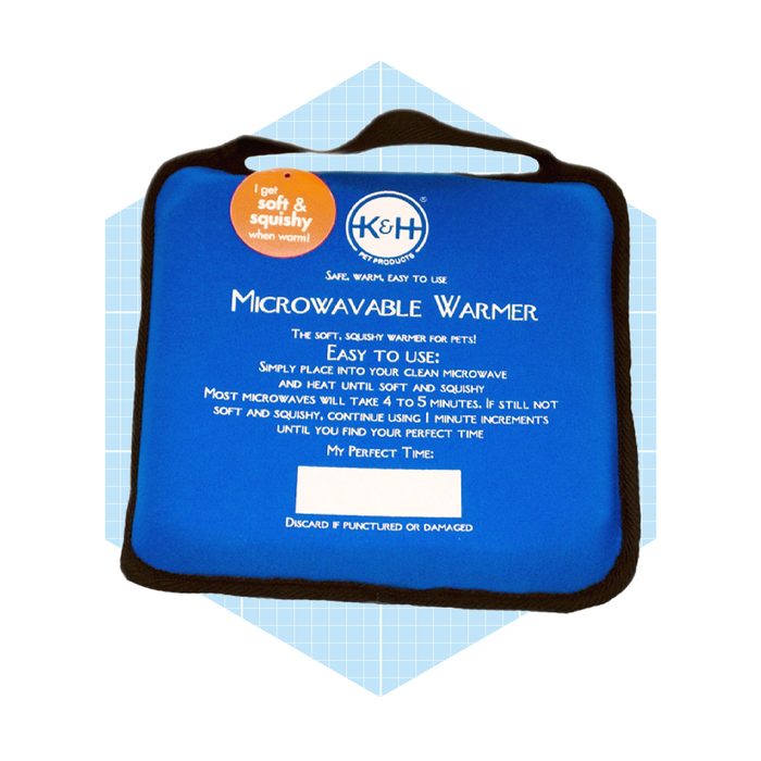 A blue microwavable warmer for pets is displayed, featuring usage instructions and a safety warning, set against a geometric light blue background.