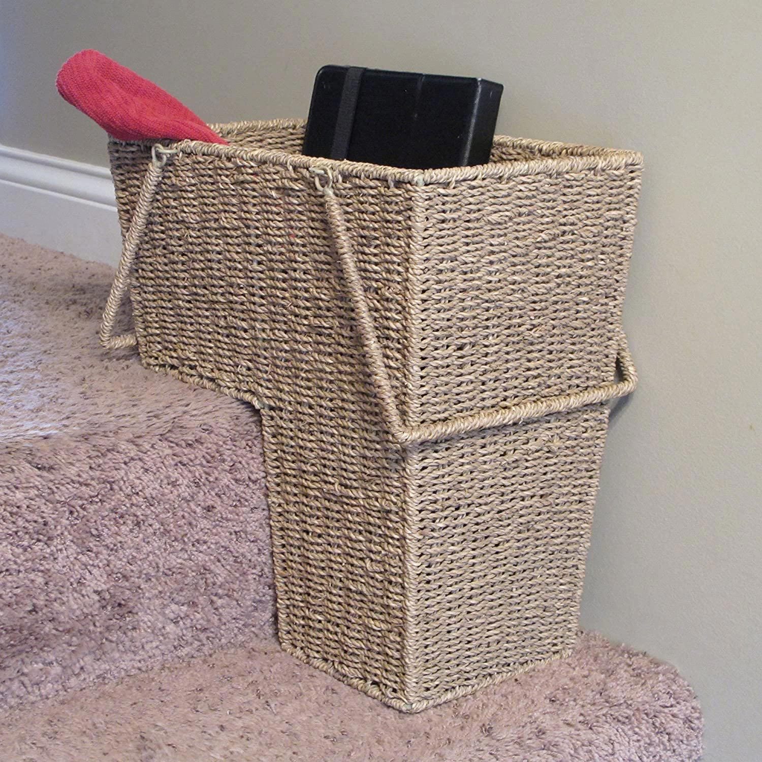 A woven basket is positioned on stairs, holding a black object and a red cloth, serving as a container for items being transported.