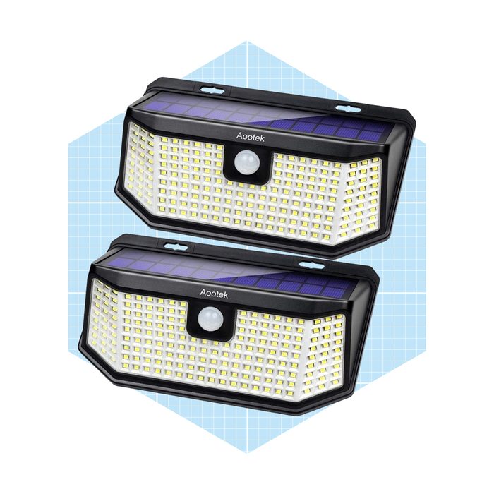 Two solar motion sensor lights are displayed, designed to illuminate surroundings when detecting movement, set against a light blue grid background.