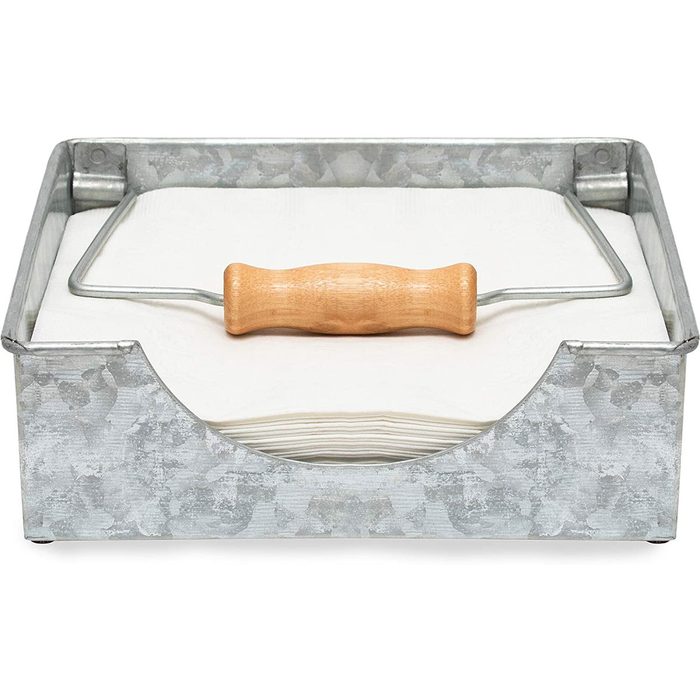 A metal paint tray with a wooden-handled roller rests atop stacked paper towels, positioned flat on a surface, ready for use.
