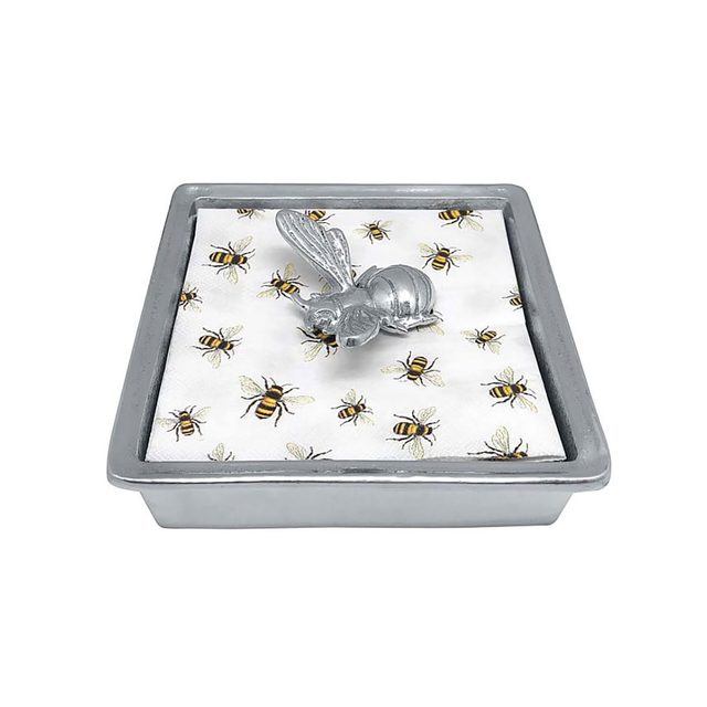 A decorative tray features a metallic bee sculpture atop a patterned fabric with small bees, set in a gray rectangular container.