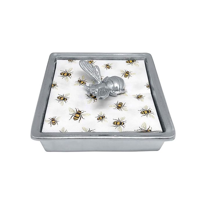 A decorative tray features a metallic bee sculpture atop a patterned fabric with small bees, set in a gray rectangular container.