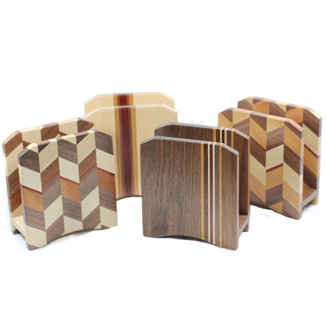 Wooden decorative holders, showcasing various geometric patterns and finishes, are arranged upright on a white background, emphasizing their craftsmanship and design.